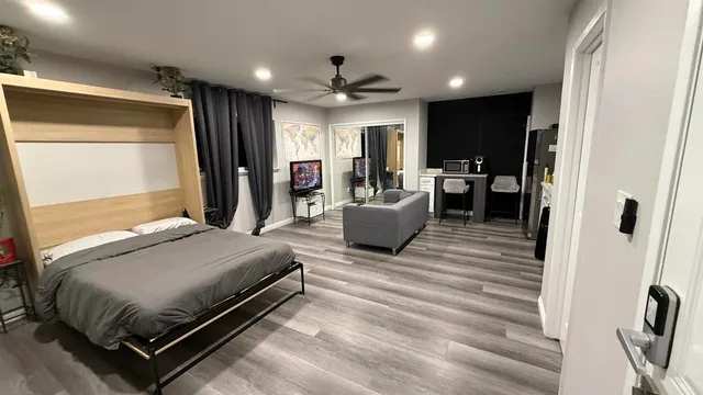 a bedroom with a bed couch and a large window