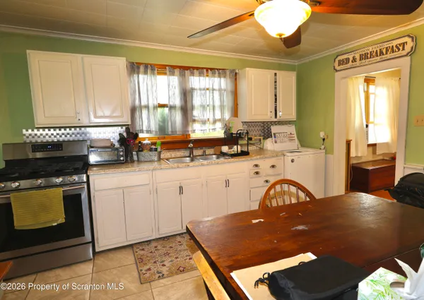 a kitchen with a table chairs sink and cabinets