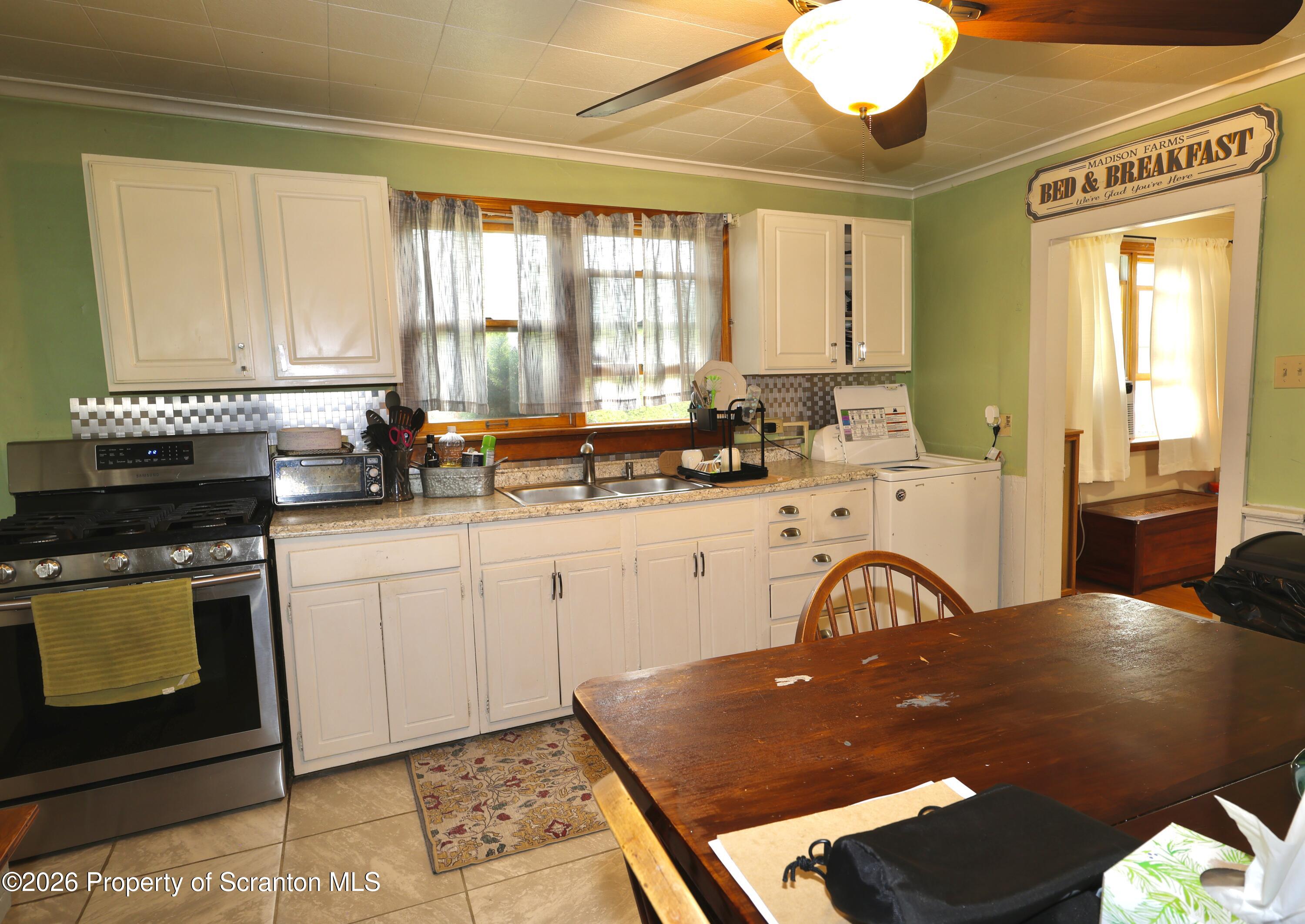 1338 Lafayette Street Scranton, PA 18504 - Photo 15 of 31 a kitchen with a table chairs sink and cabinets