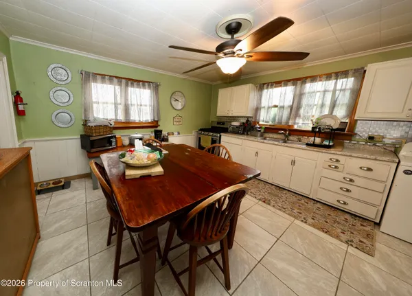 a kitchen with stainless steel appliances granite countertop a sink a stove a dining table and chairs