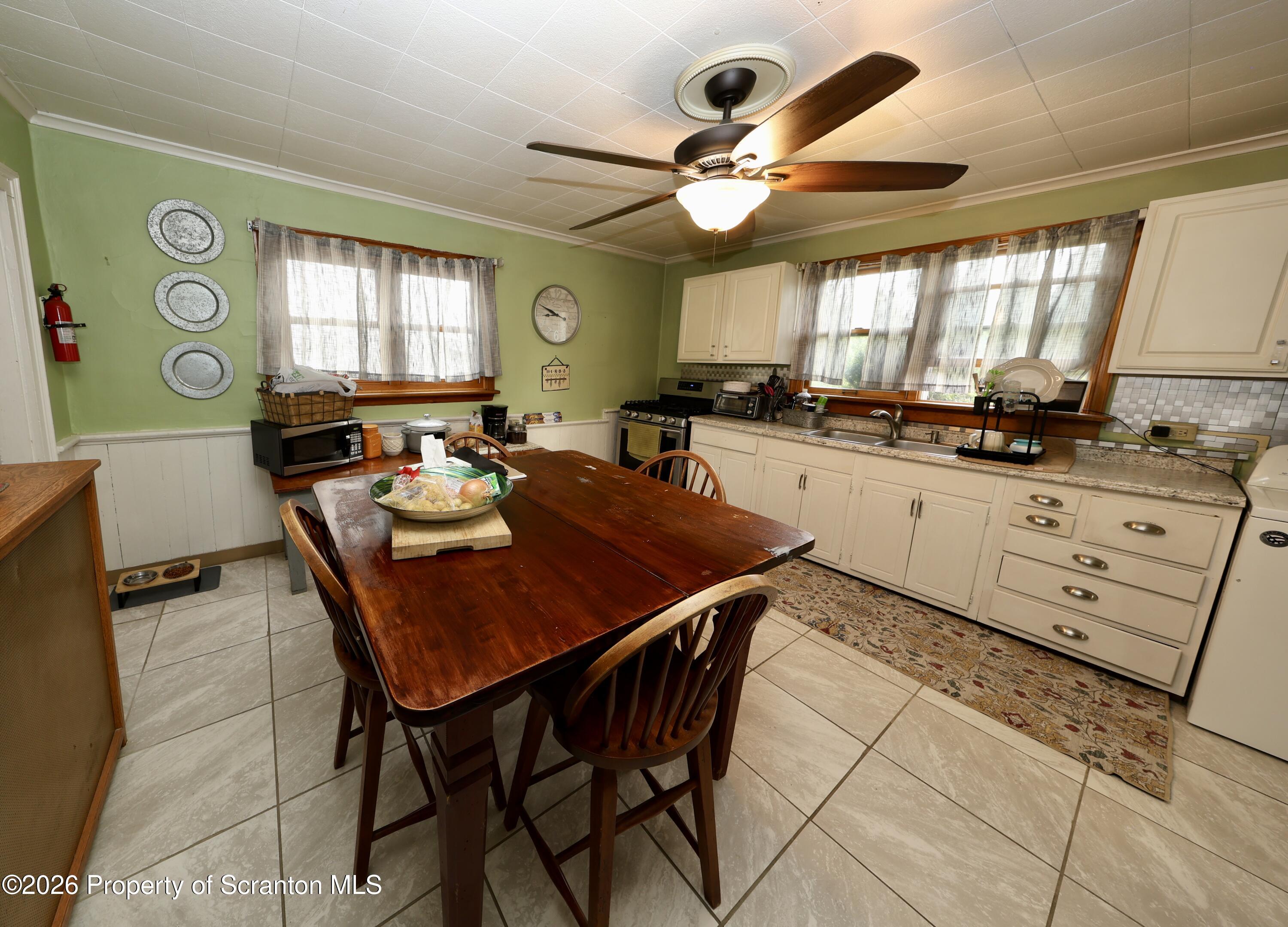 1338 Lafayette Street Scranton, PA 18504 - Photo 4 of 31 a kitchen with stainless steel appliances granite countertop a sink a stove a dining table and chairs
