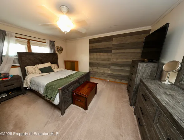 a bedroom with a bed and a flat tv screen on dresser