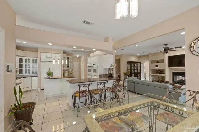 a kitchen with stainless steel appliances kitchen island granite countertop a table and chairs in it