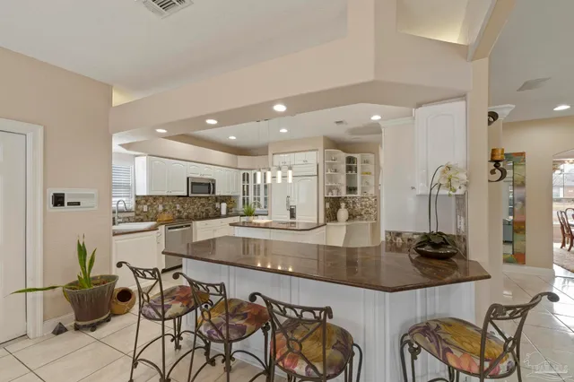 a kitchen with granite countertop a sink and white cabinets