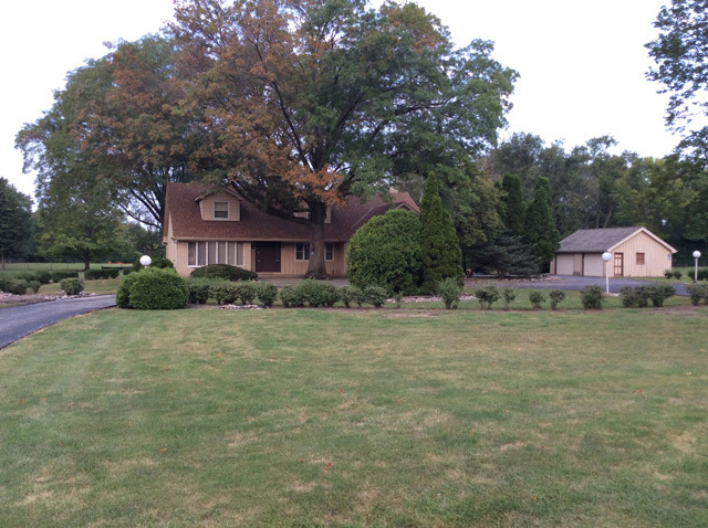 a front view of house with yard and trees
