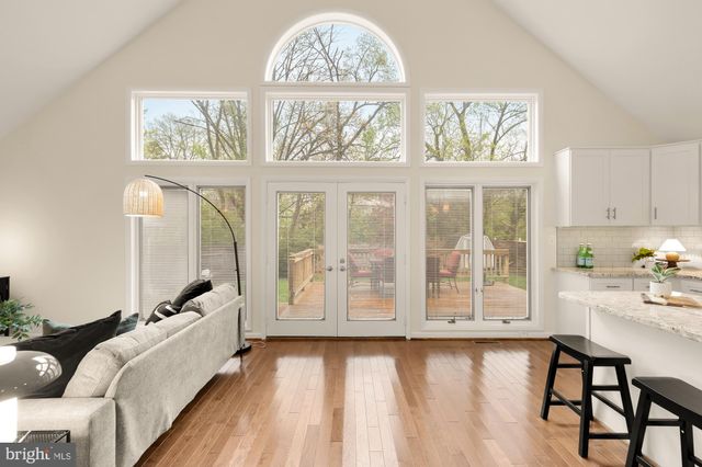 a kitchen with stainless steel appliances a white table chairs and a refrigerator