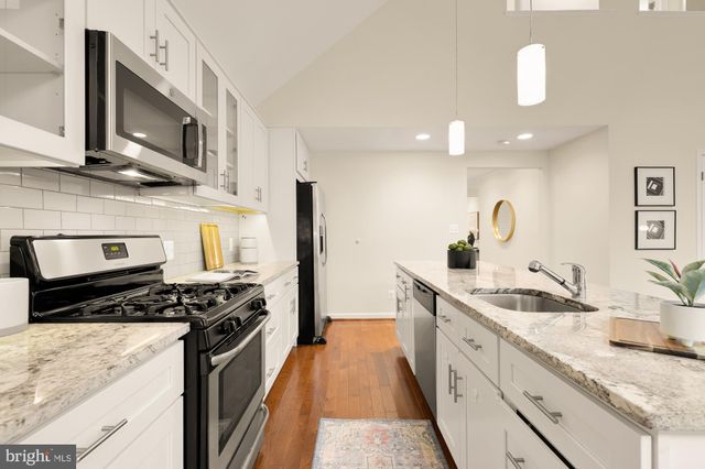 a kitchen with granite countertop white cabinets and white appliances