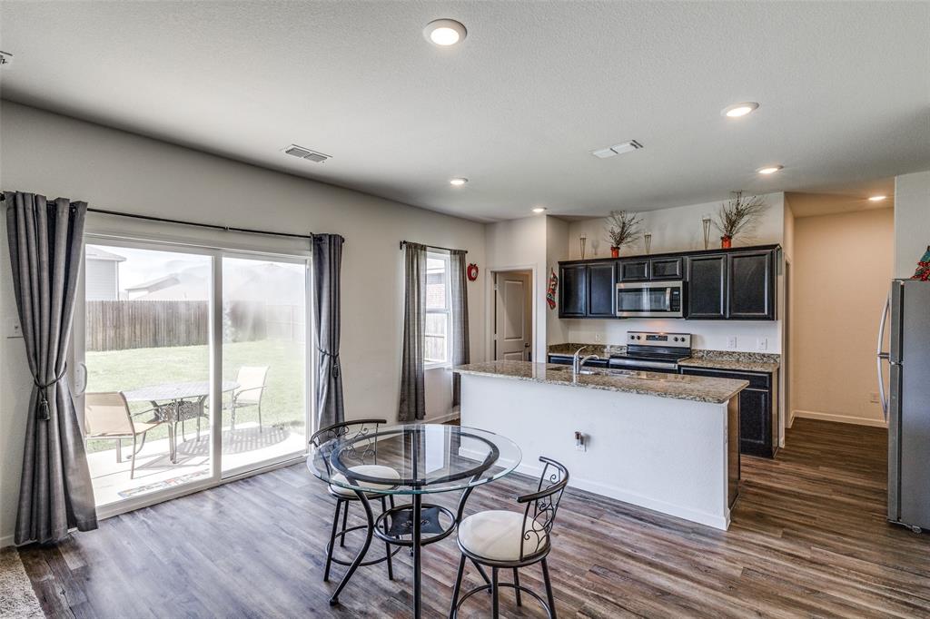 5525 McMahan Lane Fort Worth, TX 76036 - Photo 2 of 21 a kitchen with stainless steel appliances granite countertop a stove top oven a refrigerator a sink with a dining table and chairs