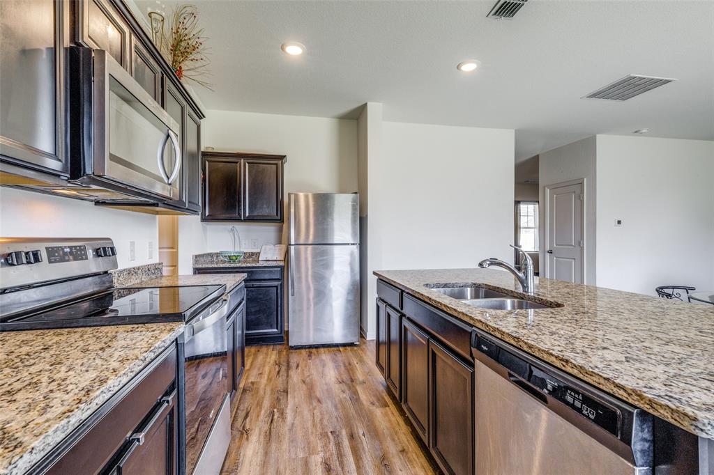 5525 McMahan Lane Fort Worth, TX 76036 - Photo 4 of 21 a kitchen with stainless steel appliances granite countertop a sink stove microwave and refrigerator
