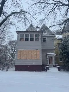 a front view of a house with yard and parking