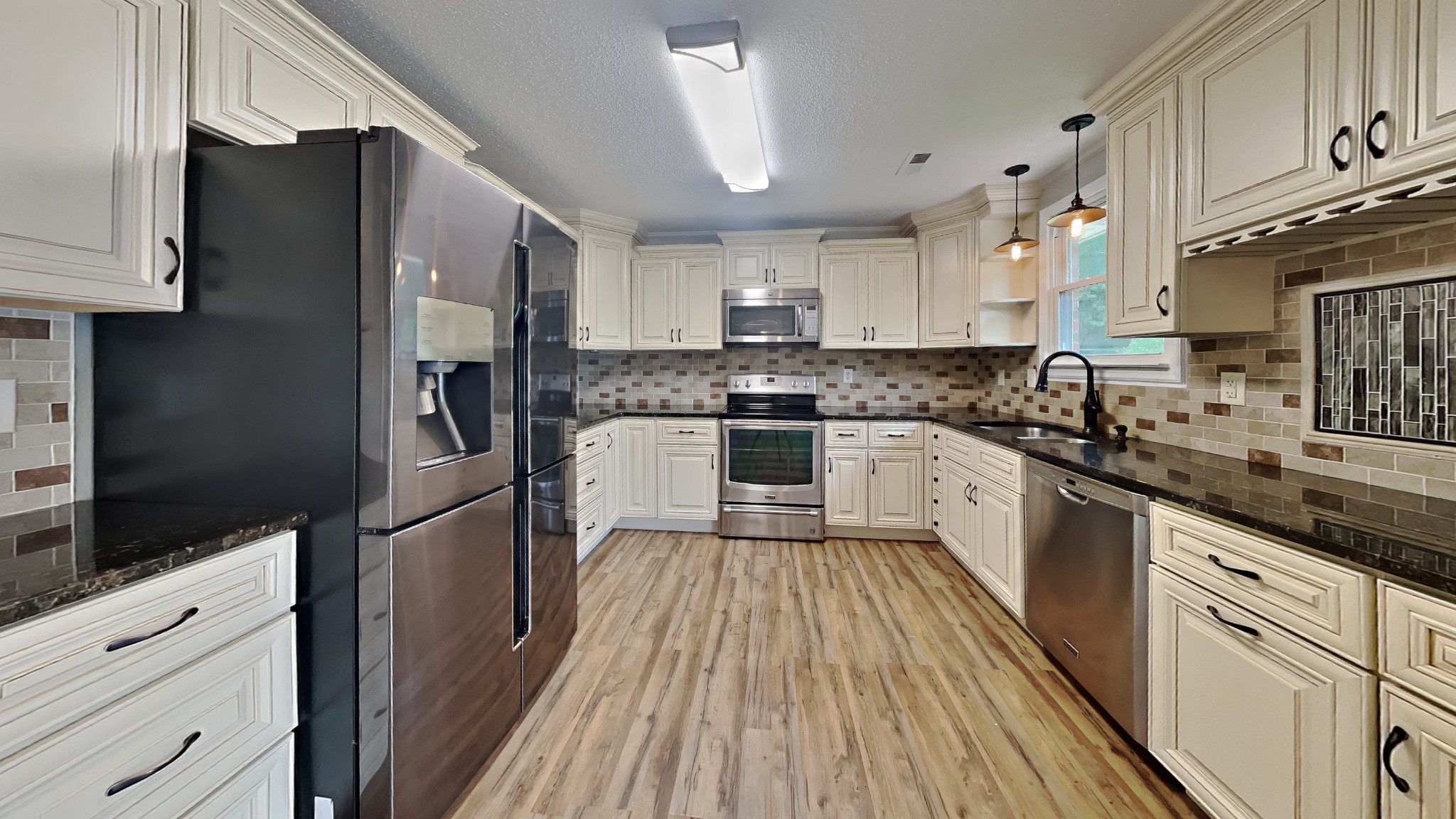 1307 Old Gratton Road Clarksville, TN 37043 - Photo 3 of 10 a kitchen with white cabinets appliances and wooden floor