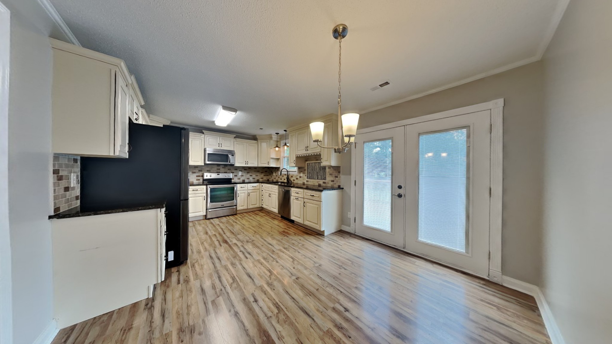 1307 Old Gratton Road Clarksville, TN 37043 - Photo 4 of 10 a view of kitchen with refrigerator microwave and stove with wooden floor