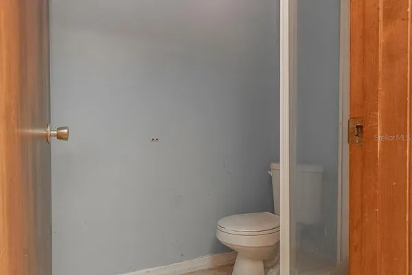 a white toilet sitting next to a shower