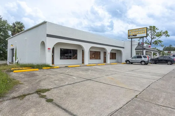 a front view of a building with cars parked