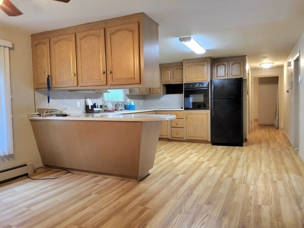 46 Lake Parkway Webster, MA 01570 - Photo 19 of 42 a large kitchen with stainless steel appliances granite countertop a refrigerator a sink dishwasher and wooden cabinets with wooden floor