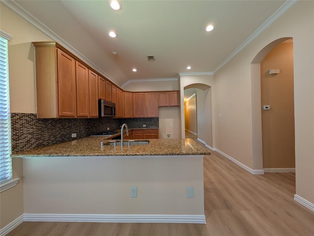 6620 Crator Drive McKinney, TX 75070 - Photo 11 of 26 a large kitchen with stainless steel appliances granite countertop a granite counter tops and a wooden floor