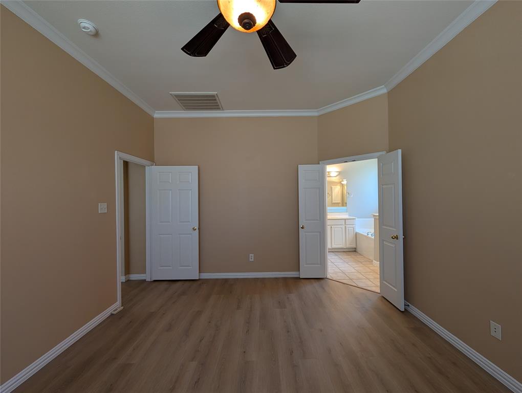 6620 Crator Drive McKinney, TX 75070 - Photo 15 of 26 an empty room with wooden floor painted walls and windows