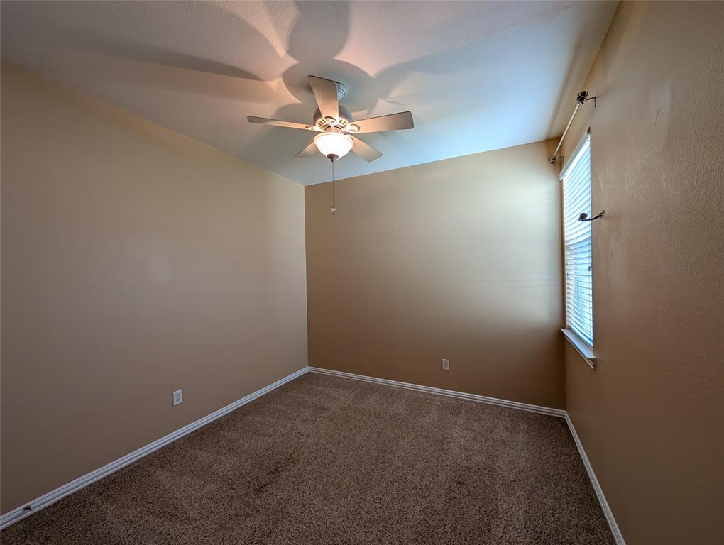 6620 Crator Drive McKinney, TX 75070 - Photo 24 of 26 an empty room with a chandelier fan and windows