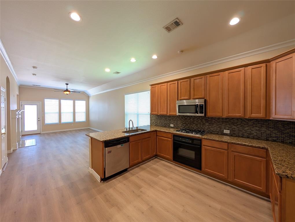 6620 Crator Drive McKinney, TX 75070 - Photo 8 of 26 a kitchen with granite countertop a stove top oven and cabinets