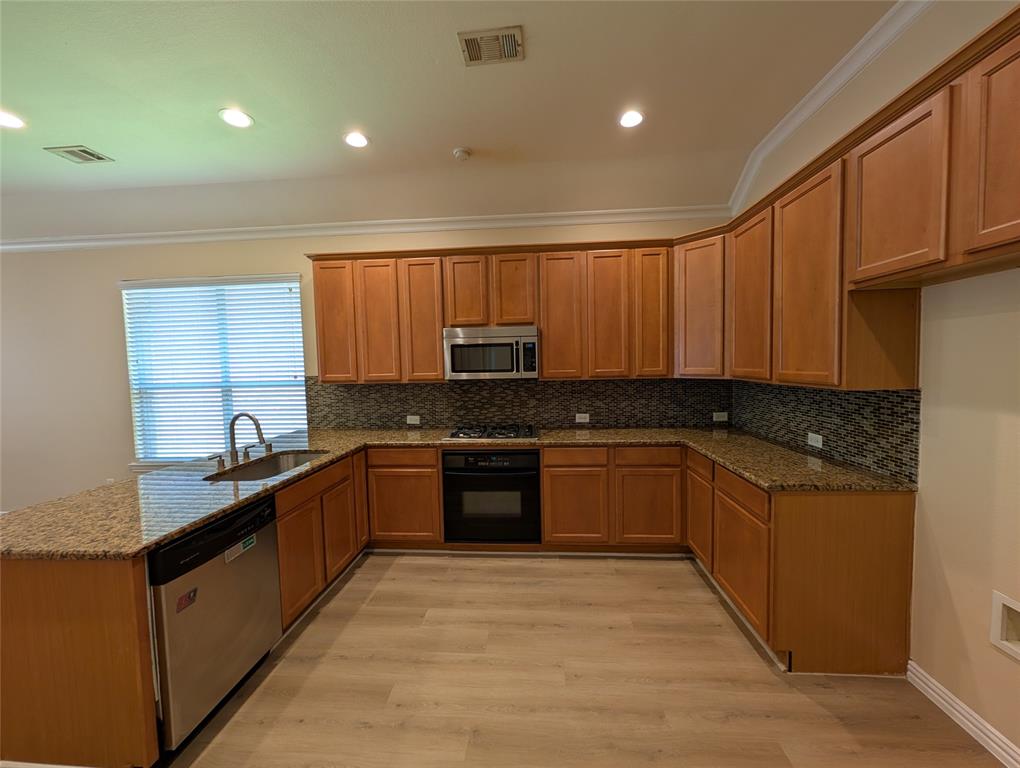 6620 Crator Drive McKinney, TX 75070 - Photo 9 of 26 a large kitchen with granite countertop a sink and stove top oven