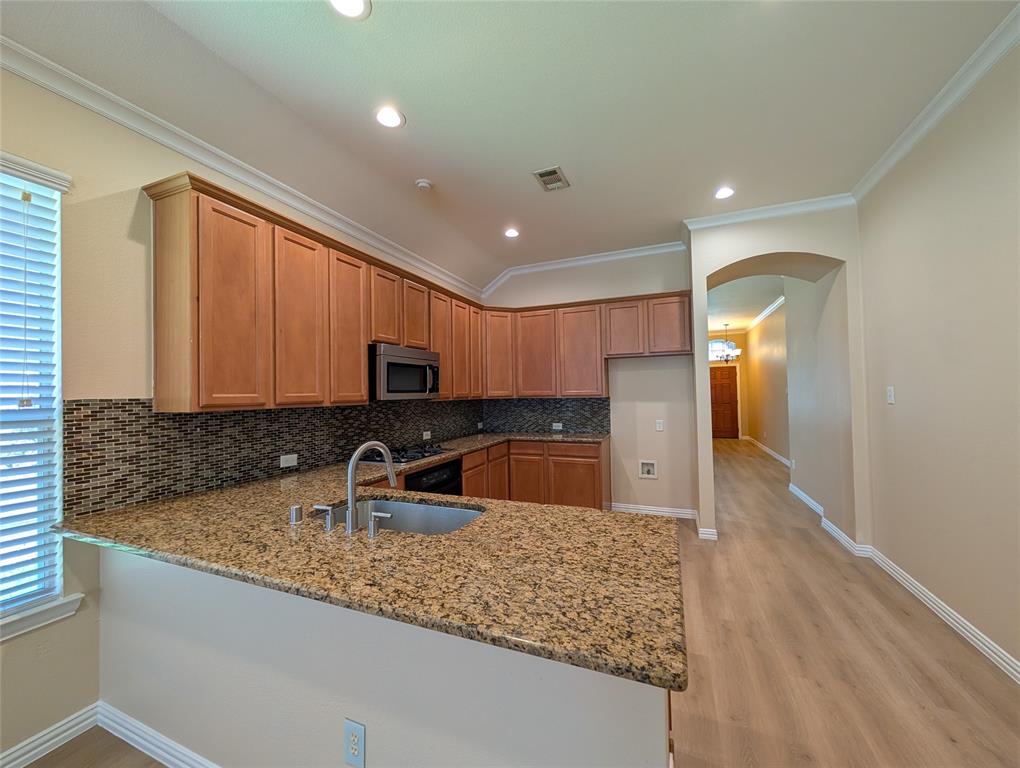 6620 Crator Drive McKinney, TX 75070 - Photo 10 of 26 a kitchen with stainless steel appliances granite countertop a sink a stove and a refrigerator