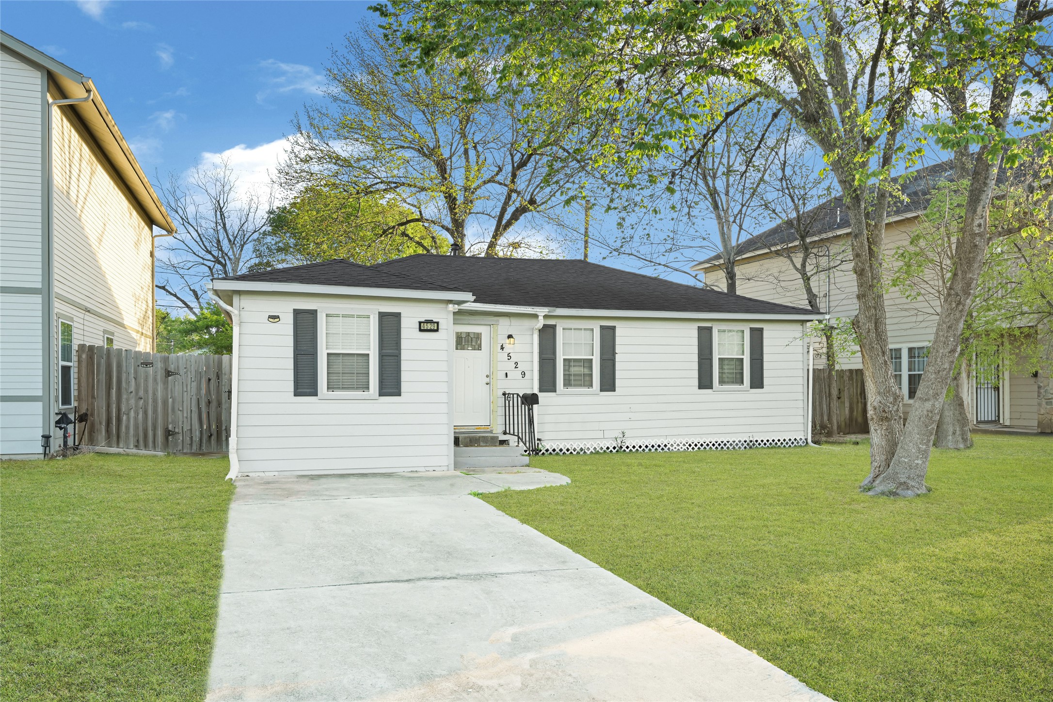 a front view of a house with a yard and trees