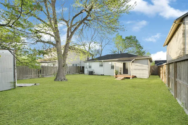 a view of a house with a yard and tree