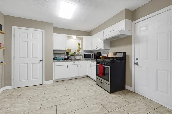 a kitchen with stainless steel appliances granite countertop a stove a sink and a refrigerator