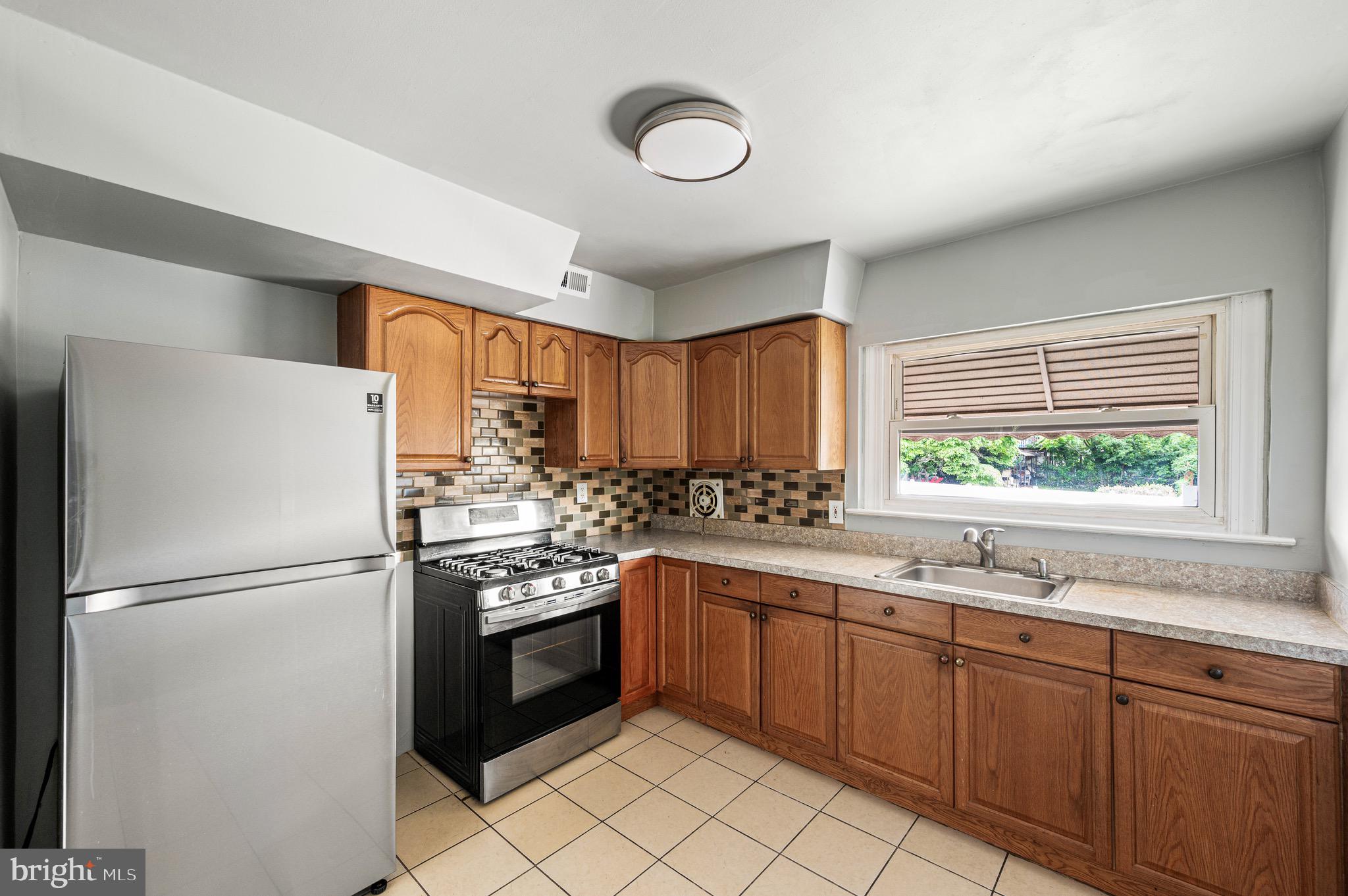 3583 Nottingham Lane Philadelphia, PA 19114 - Photo 8 of 23 a kitchen with stainless steel appliances granite countertop a refrigerator a sink dishwasher a stove with white cabinets and wooden floor