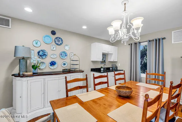 a kitchen with stainless steel appliances a dining table and chairs in it
