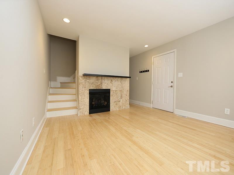 2554 Noble Road Raleigh, NC 27608 - Photo 3 of 11 a view of empty room with wooden floor and fireplace