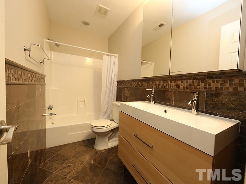 2554 Noble Road Raleigh, NC 27608 - Photo 10 of 11 a bathroom with a sink a toilet and shower