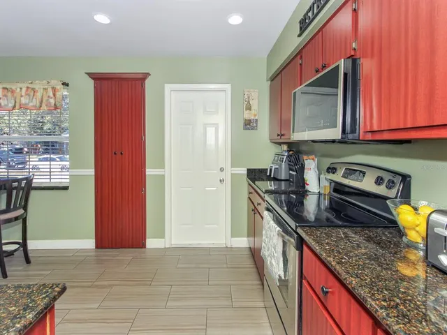 a kitchen with stainless steel appliances granite countertop a stove a sink and a microwave