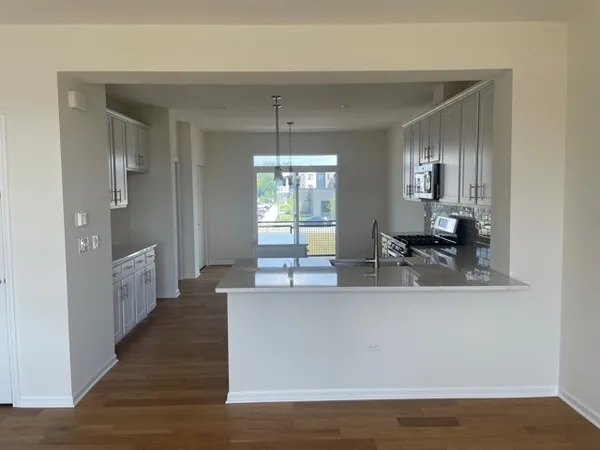 a kitchen with stainless steel appliances granite countertop a sink a stove and a microwave