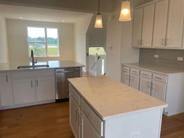 a kitchen with a wooden floor and a large window