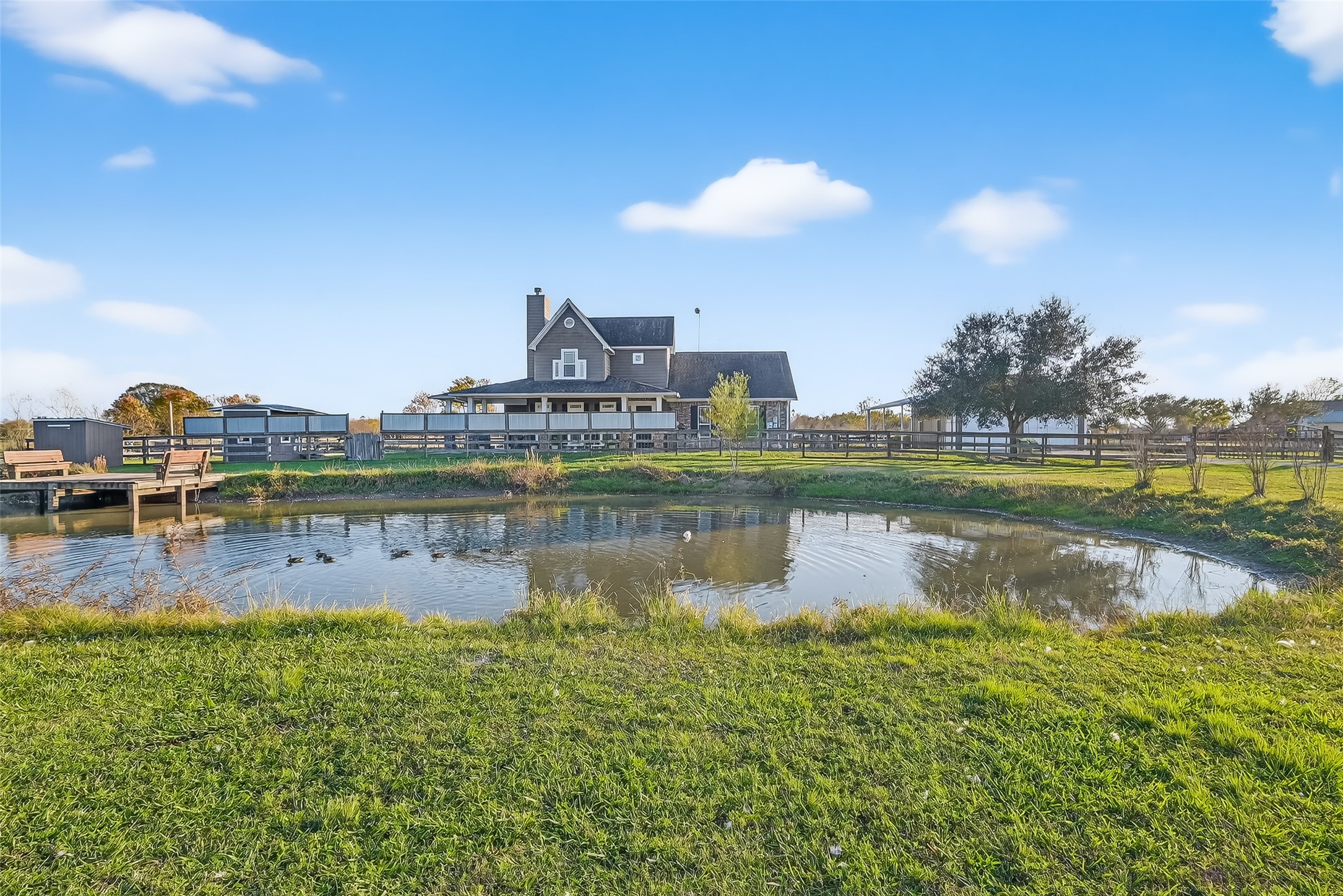 This idyllic property features a charming house with a wrap-around porch, set on expansive grounds with a peaceful pond. Perfect for those seeking a serene, countryside retreat.