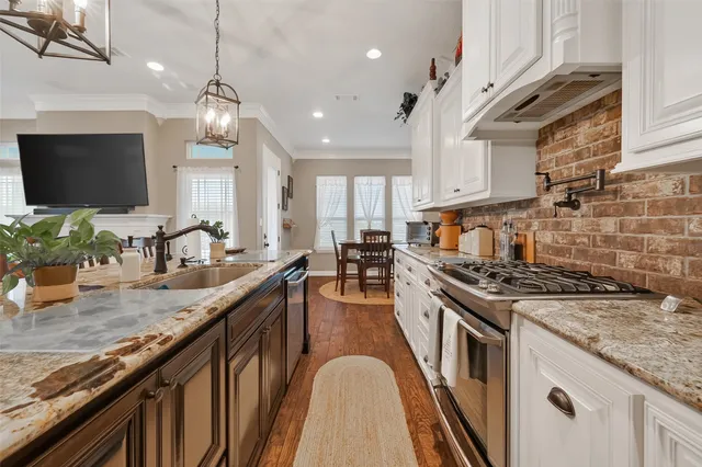 a kitchen with stainless steel appliances granite countertop a lot of counter space and wooden floors