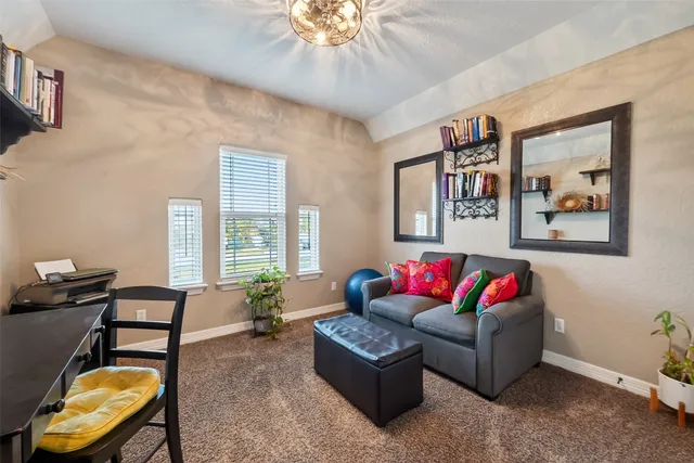 a living room with furniture and paintings on the wall