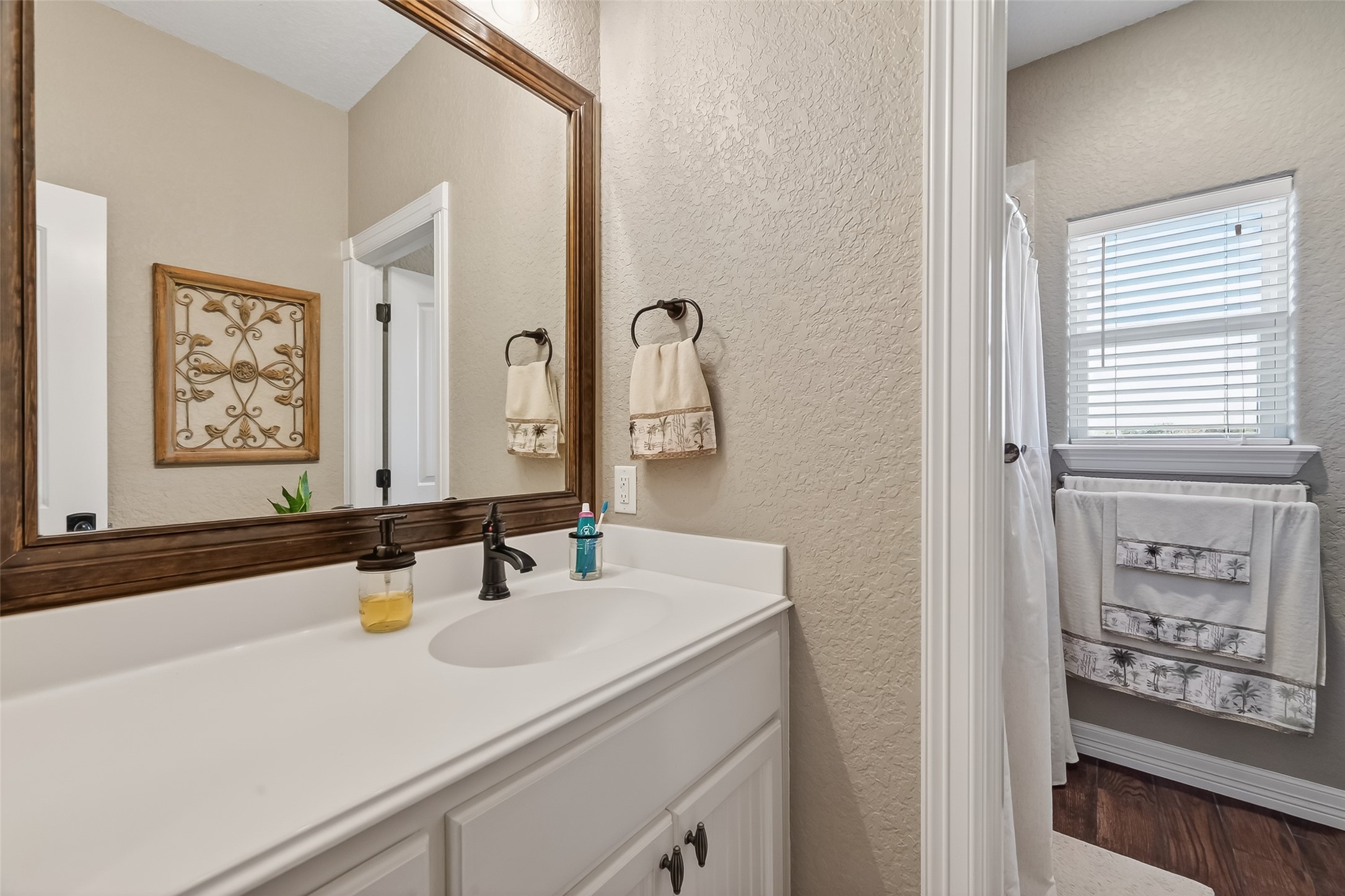 912 County Road 340 Angleton, TX 77515 - Photo 24 of 50 This bathroom features a clean design with a single sink vanity, framed mirror, and neutral color palette. It includes a shower and a window for natural light.