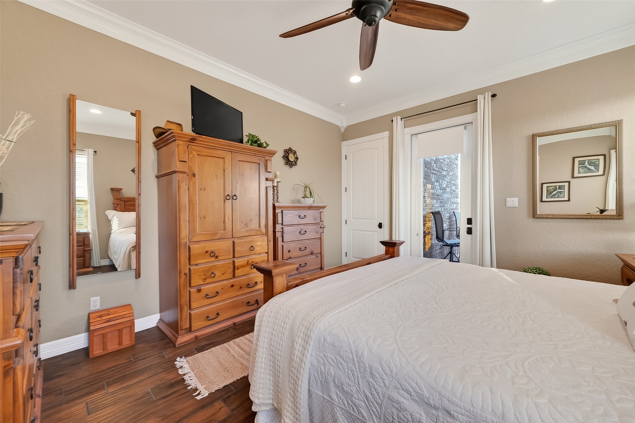 912 County Road 340 Angleton, TX 77515 - Photo 28 of 50 This cozy bedroom features warm neutral walls and a ceiling fan. It has a door leading to an outdoor space. Natural light enhances the inviting atmosphere.