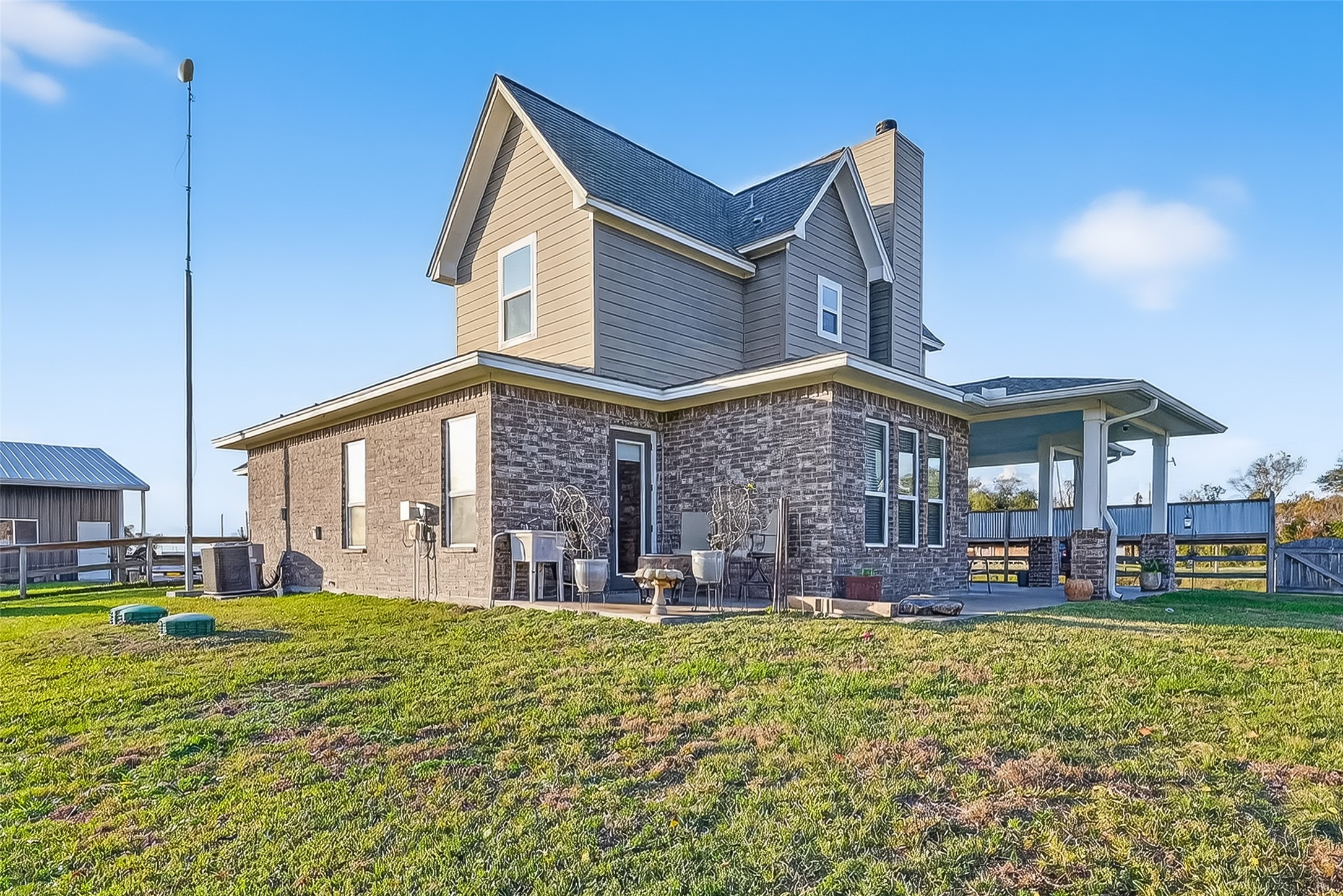 912 County Road 340 Angleton, TX 77515 - Photo 4 of 50 Charming country home with a mix of stone and siding exterior, featuring a cozy porch and ample yard space. Ideal for enjoying peaceful rural living.