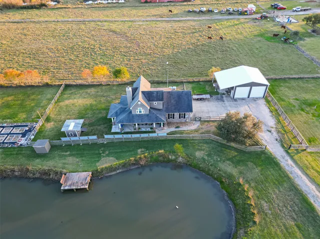 an aerial view of a house with a garden and lake view