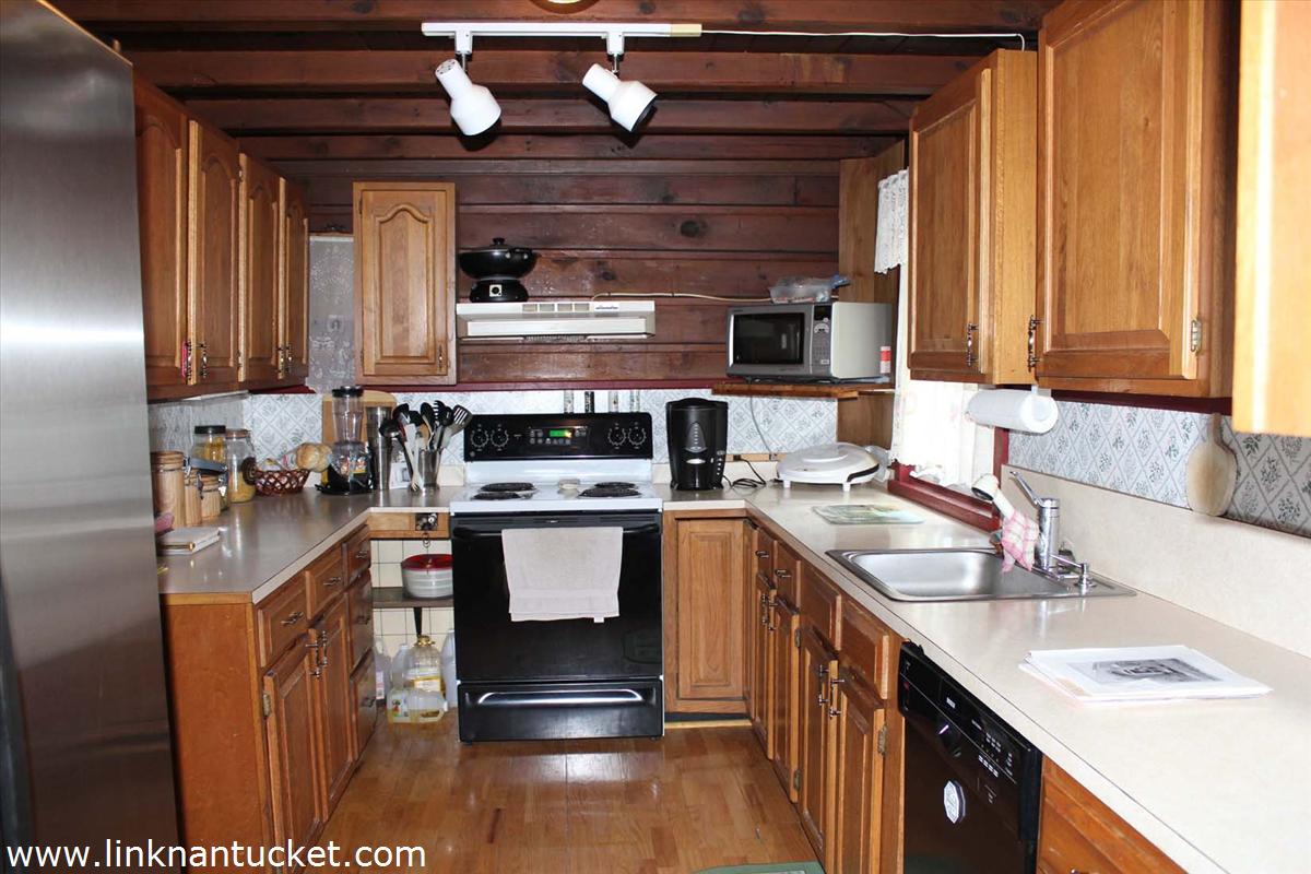 47 A Fairgrounds Road Nantucket, MA 02554 - Photo 6 of 9 a kitchen with stainless steel appliances granite countertop a sink stove and cabinets