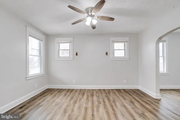a view of a livingroom with wooden floor and a kitchen
