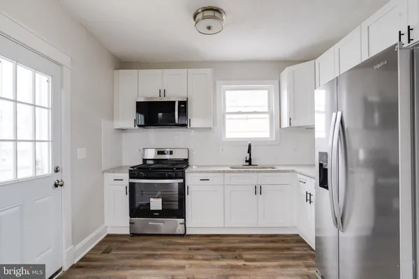 a kitchen with stainless steel appliances a refrigerator stove and microwave