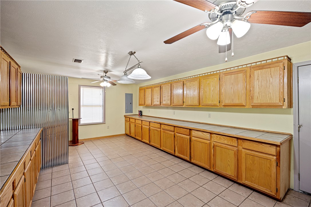 655 Charton Road Morrilton, AR 72110 - Photo 13 of 49 Spacious room featuring extensive cabinetry with wood-finish doors, tiled countertops, and light-toned walls