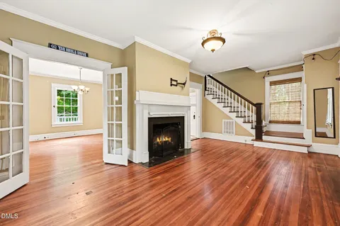 a view of a livingroom with wooden floor and a fireplace