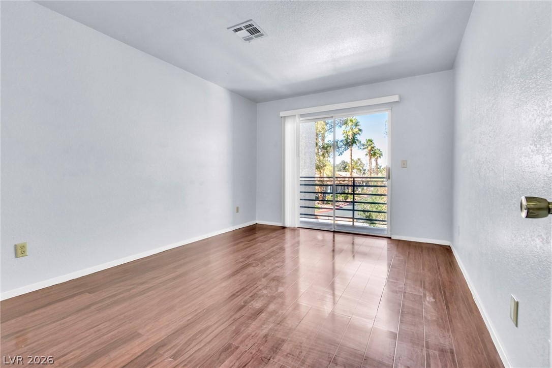 6250 West Flamingo Road, Unit 98 Las Vegas, NV 89103 - Photo 21 of 40 Spare room with wood finished floors, a textured wall, baseboards, and visible vents