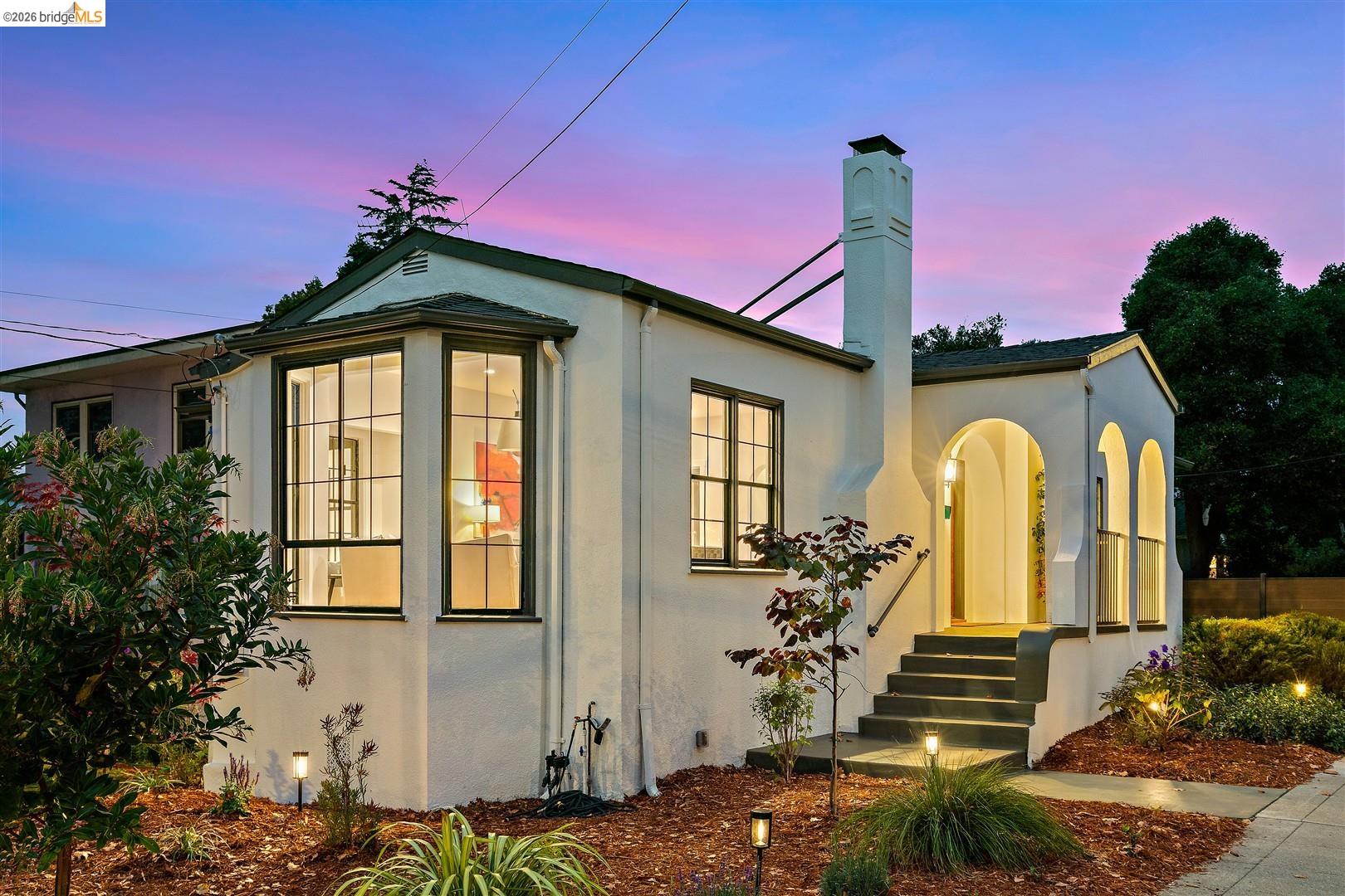 1668 Arch Street Berkeley, CA 94709 - Photo 2 of 78 Stucco exterior featuring a prominent bay window, arched entryway, and a stepped-back chimney
