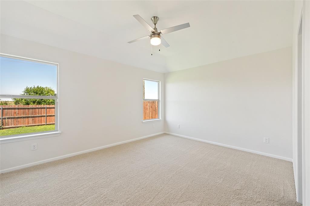 857 Watson Way Crowley, TX 76036 - Photo 18 of 25 Carpeted room featuring multiple windows, a ceiling fan with integrated lighting, and a white baseboard trim